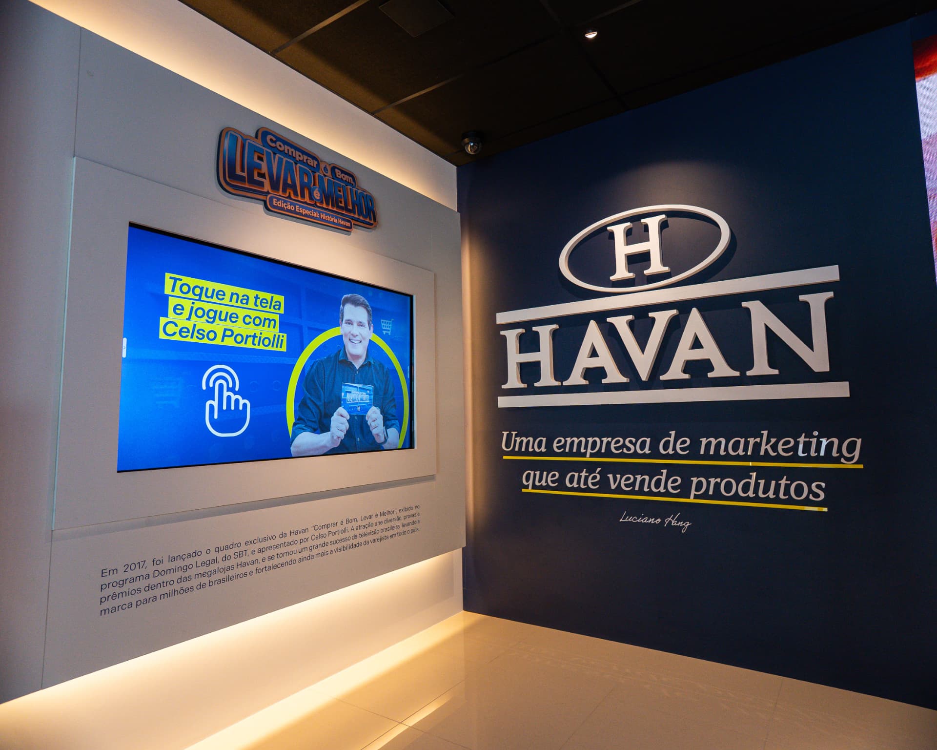 Parede de telas com campanhas e o quadro Comprar é bom, levar é melhor